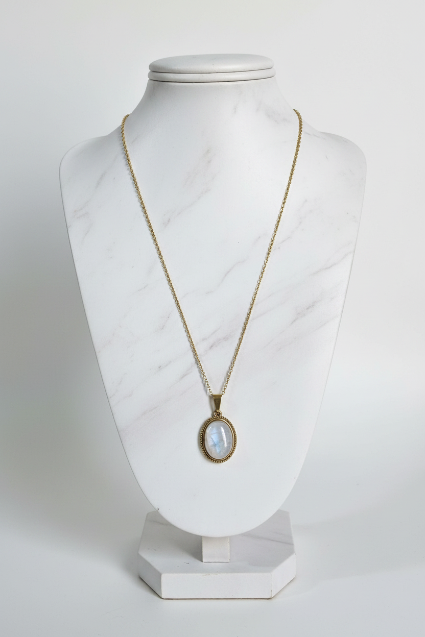 Collar de piedra luna con cadena de acero dorado sobre expositor elegante, fondo blanco