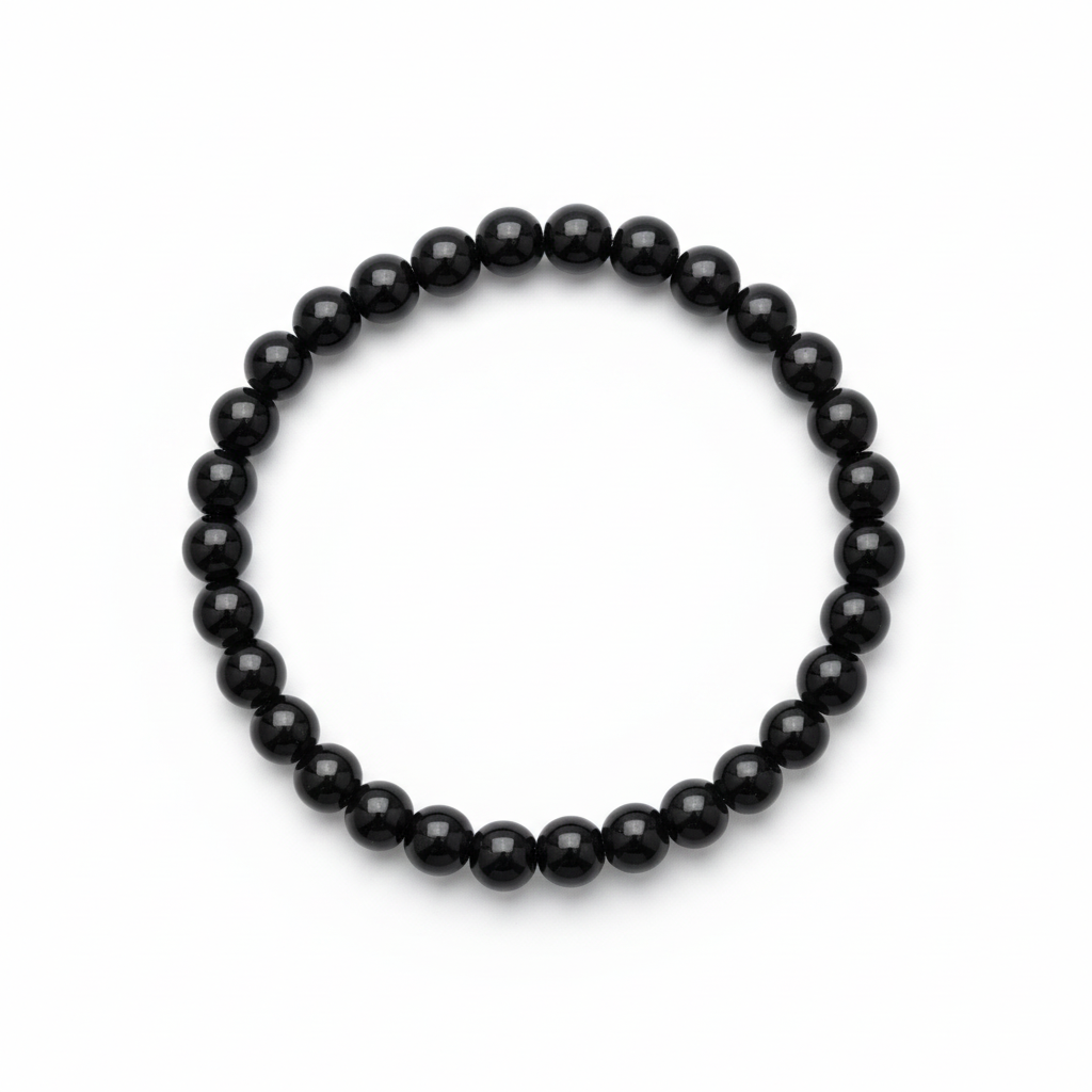Pulsera infantil elástica de obsidiana negra con una cuenta más pequeña sobre fondo blanco