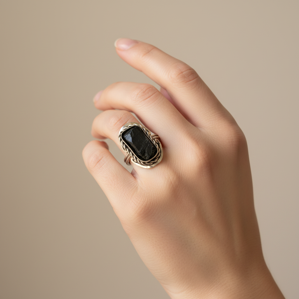 Anillo de turmalina puesto en el dedo de una mano femenina